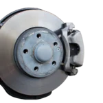 Mechanic inspecting a wheel rim with visible brake dust near the brake rotor