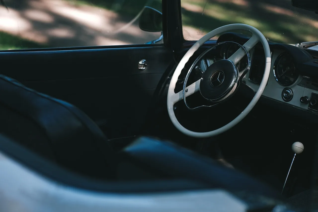Car owner inspecting a sunlit sedan interior for the source of a bad smell