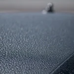 Car owner comparing polish and wax beside a sedan with light swirl marks