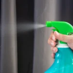 Ceramic spray for cars being applied to a sedan hood with microfiber towels and detailing tools