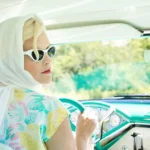 Person checking a smelly car interior with cleaning supplies and an open door in natural light