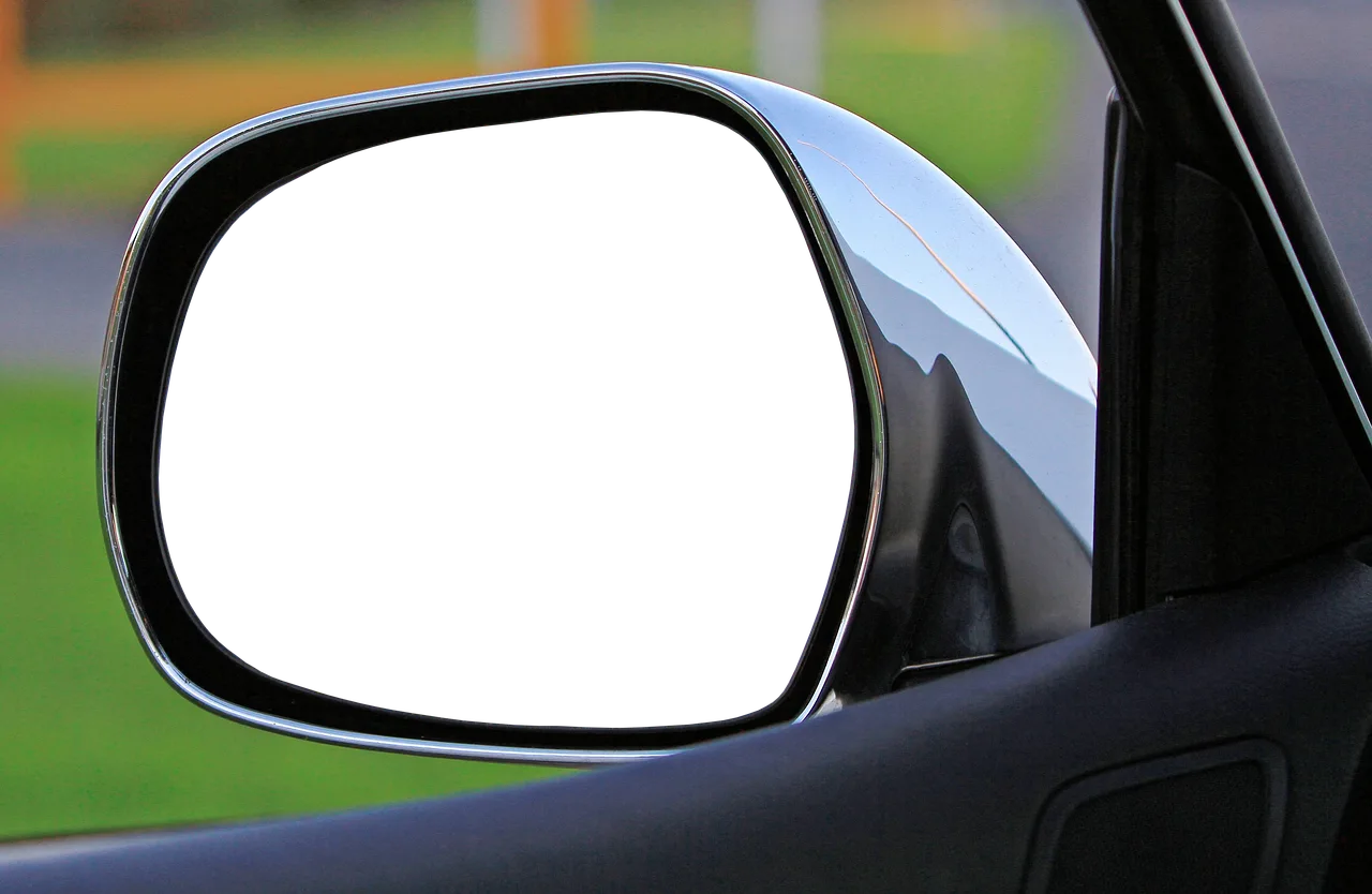 Person inspecting a used car interior with open doors and a flashlight near damp seat seams