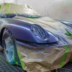 Daily driven car parked outside with water beading on the hood after rain