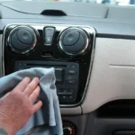 A mechanic and driver inspect a car interior for the source of a bad smell.