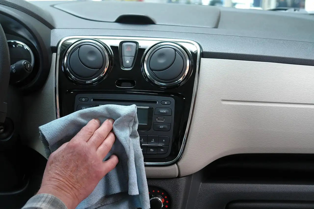 A mechanic and driver inspect a car interior for the source of a bad smell.